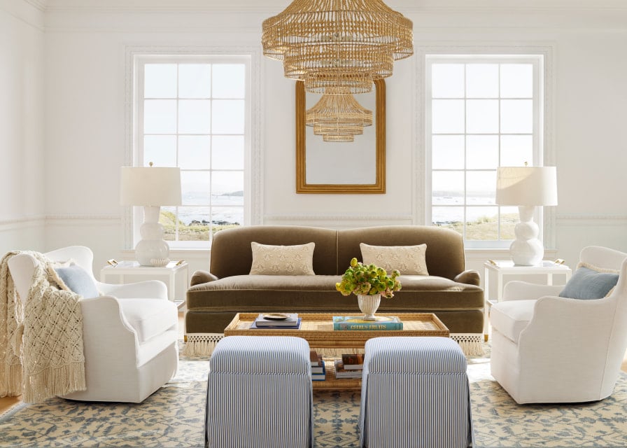 Serena & lily breathtaking living room with a hanging chandelier and green velvet sofa