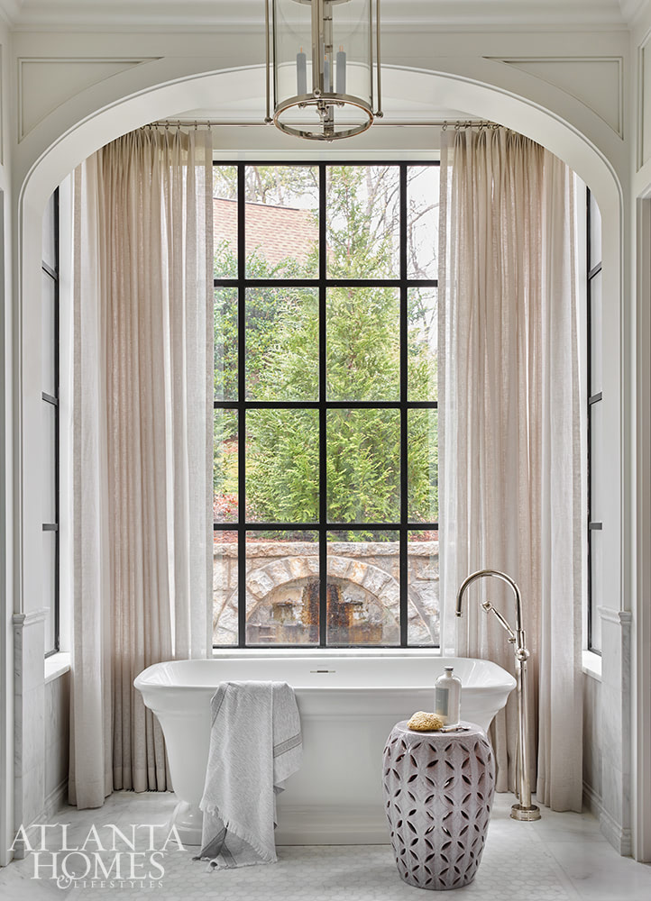 Interior Design: Melanie Milner and Katie Moorhouse of Design Atlelier - Photography: David Christensen - bathroom - bathroom design - bathroom mirror - bathroom tile - bathroom decor - arch - freestanding tub -Southern Home with Plenty of Style