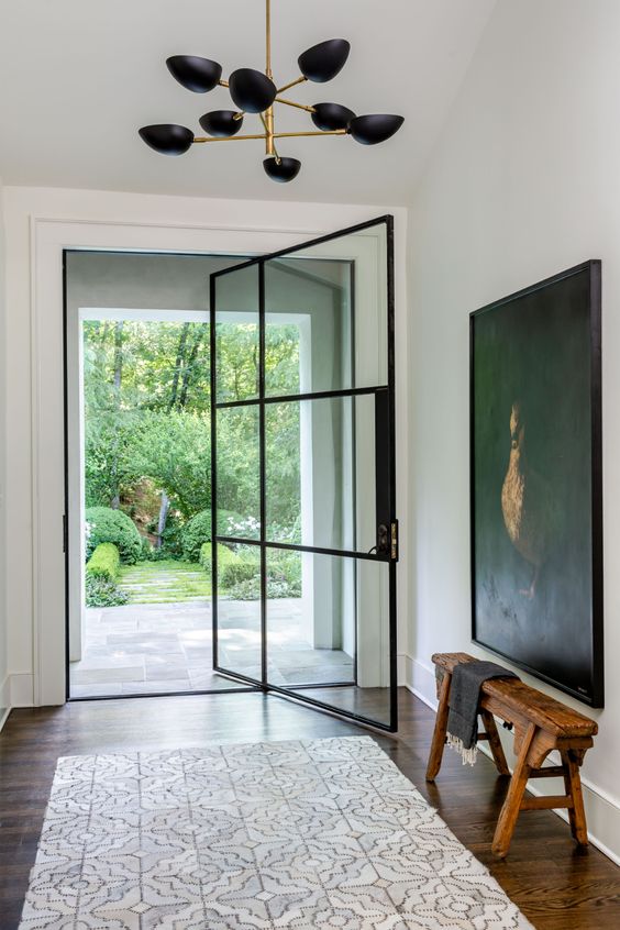 Chicly Elegant by Nancy Duffey Interiors - Jeff Herr Photography - abstract art - black and white - black steel door - chandelier