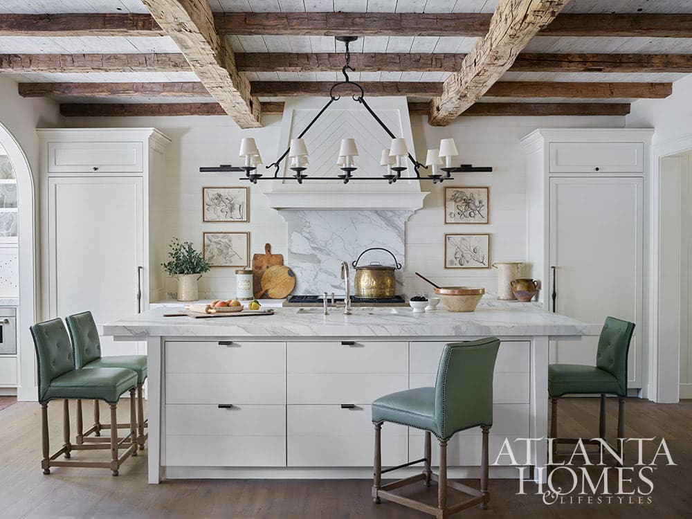 White kitchen with wood beams and honed marble countertops - Source: Atlanta Homes & Lifestyles Interior Design: Lanier Interiors Architect: Steve Fintak of D Stanley Dixon Architect Photography: Emily Followill Landscape Architect: Jonathan Bussell Builder: Smith Built Homes