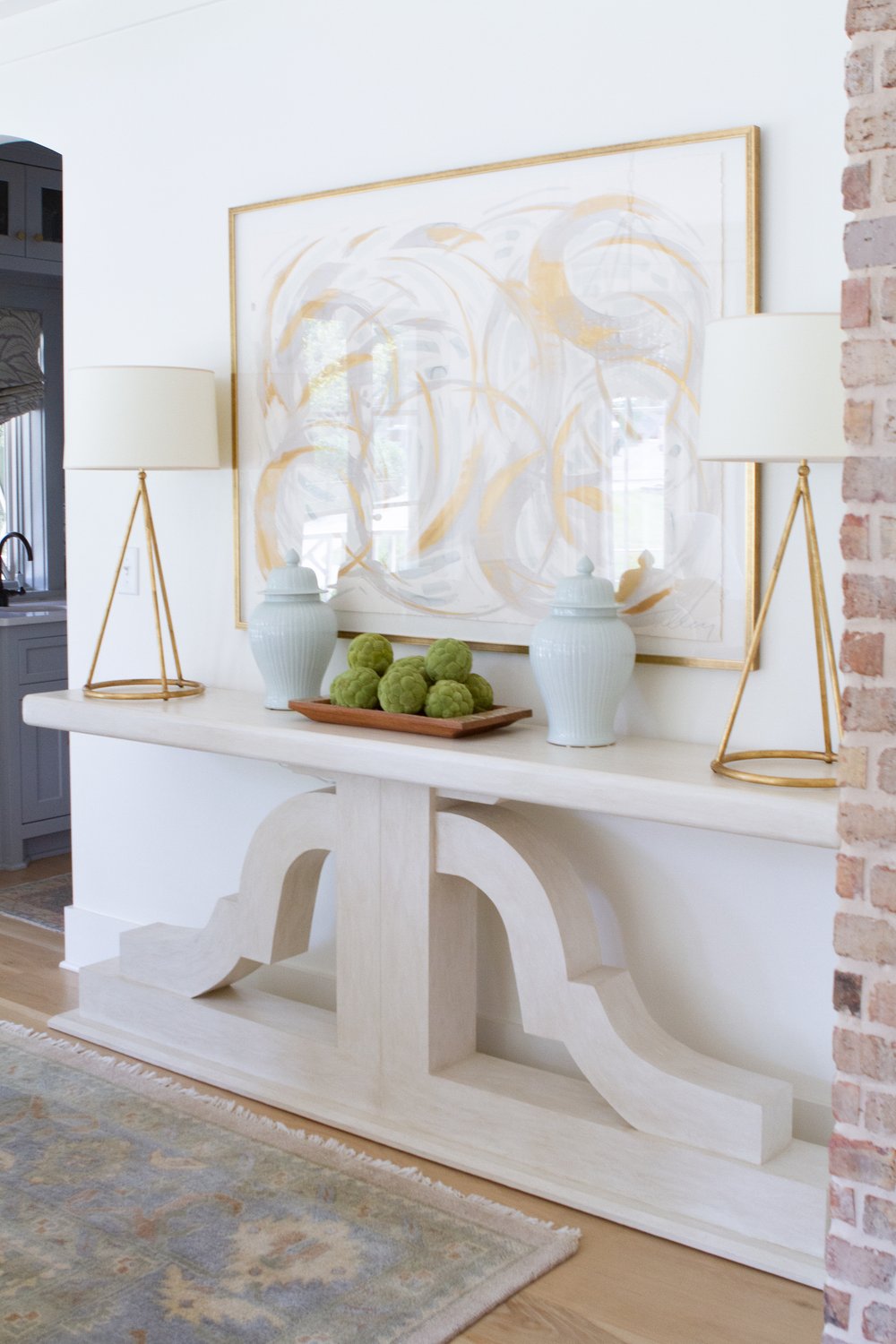 Step inside these family-friendly design ideas with timeless elegance by the talented Emily Haraf of EH Interiors. Foyer with console table and a pair of Visual Comfort lamps and abstract art -INSTAGRAM: @eh_interiors Kristen Mayfield Photography INSTAGRAM: @kristen.mayfield