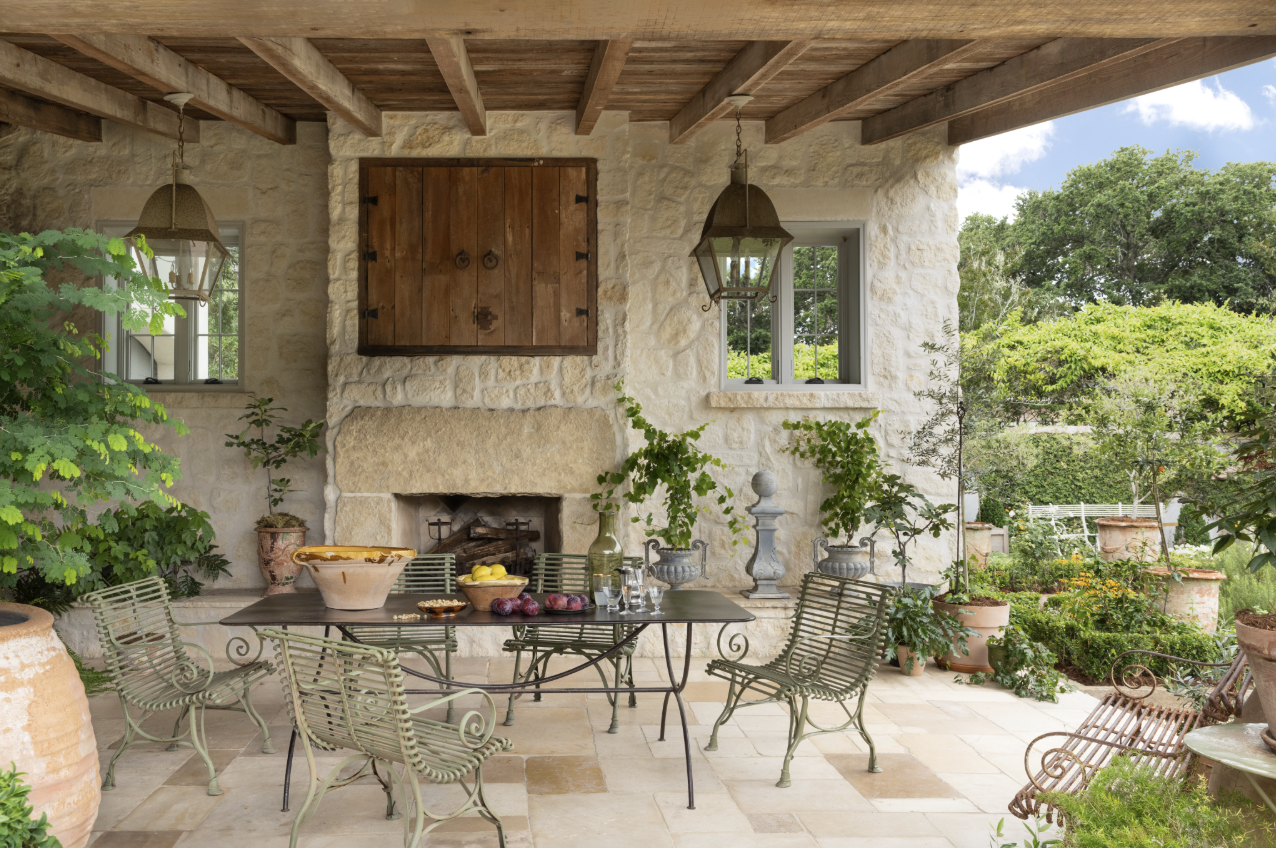 Inviting covered porch with a fireplace perfect for chilly nights designed by architect T. S. Adams - 