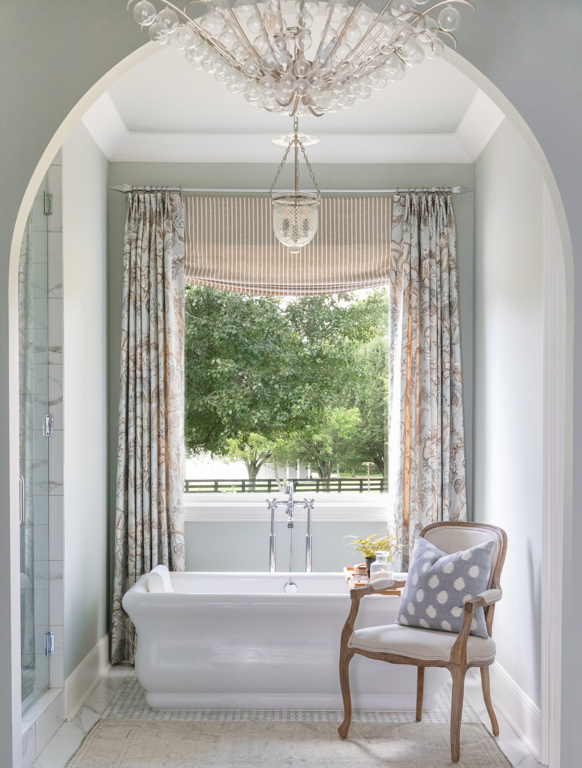 Nashville Interior Designer, Eric Ross creates stunning, homes with enduring classic style. Evin Photography -beautiful bathroom with freestanding tub and crystal chandelier