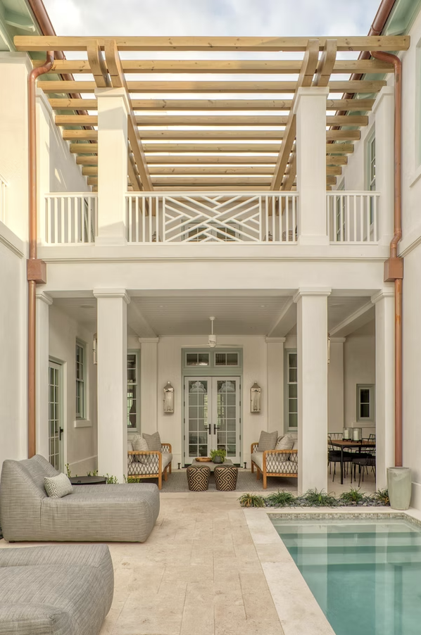 If you're in the mood for a vacation today, but can't leave town, don't worry! One peek at this stunning coastal home on Alys Beach designed by Brad Ramsey Interiors  and, you'll feel like you're a million miles away! Jack Gardner PHotography - white house with light shutters and a wading pool