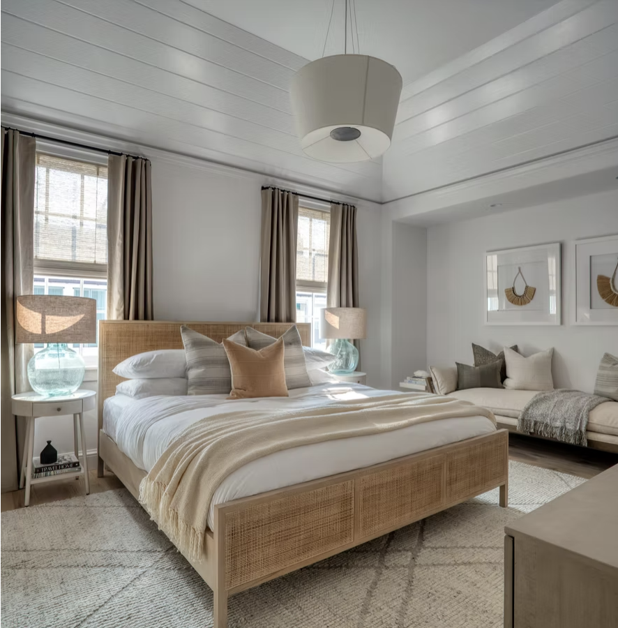 If you're in the mood for a vacation today, but can't leave this stunning coastal home in Alys Beach designed by Brad Ramsey Interiors makes you feel like you're a million miles away! Jack Gardner Photography - primary bedroom with rattan bed and shiplap